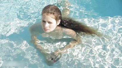 Beautiful Redhead's Playful Charm by the Poolside